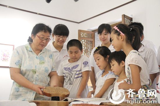 东昌府区年画社社长徐秀贞向同学们讲解年画制作过程。