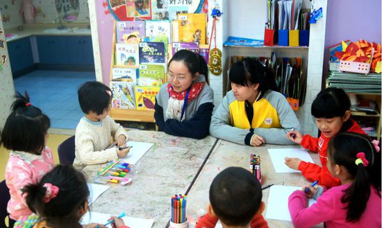 工美附中学生在辅导幼儿园小朋友学习绘画