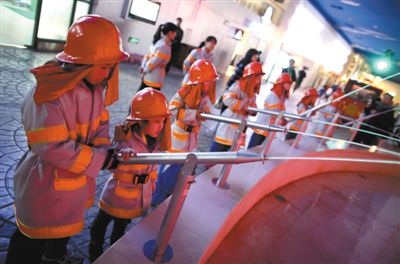 小学生们在体验如何做一名消防员。新京报记者