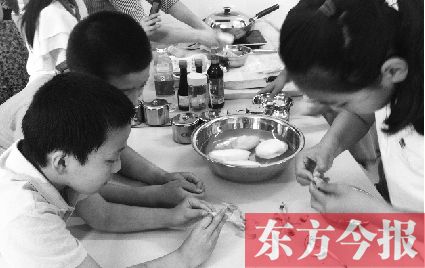 美食课堂上,小学生正专注地剥蒜