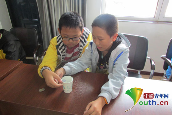 参加周末课堂活动的留守儿童在做“硬币存水”科普实验。哈尔滨工程大学支教团供图 参加周末课堂活动的留守儿童在做“硬币存水”科普实验。哈尔滨工程大学支教团供图