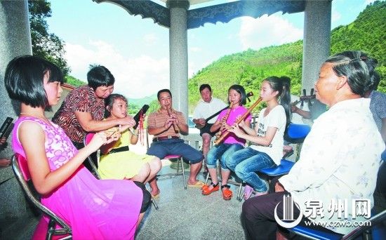 孩子们在凉亭里跟着村里的长辈学习南音