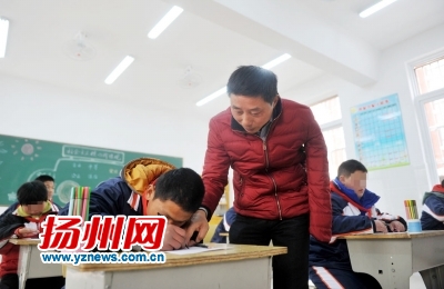 课堂上,单成学正在教一名学生画画。 课堂上,单成学正在教一名学生画画。