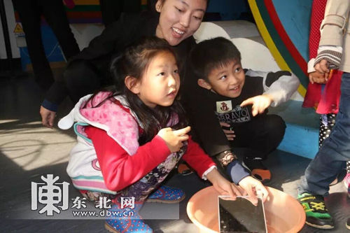 小朋友通过自己动手在墙上映出彩虹。