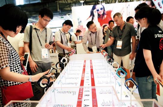 7 月15 日,观众在“世界移动大会·上海”暨上海国际信息消费节上试戴智能手环 中国经济:如何让消费引擎更强劲