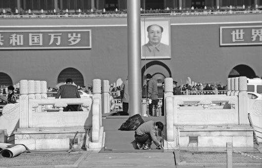 1日,天安门广场上工作人员认真铺设红地毯,为两会期间升国旗仪式做好准备。