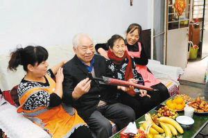 昨日,养老护理员在全国劳模周福英老人(右二)家中,为她和老伴做推拿按摩。
