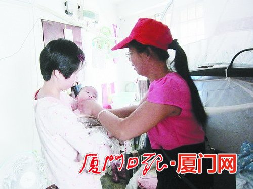 李丽上门看望刚生完宝宝的社区姐妹。(陈明芳 摄)